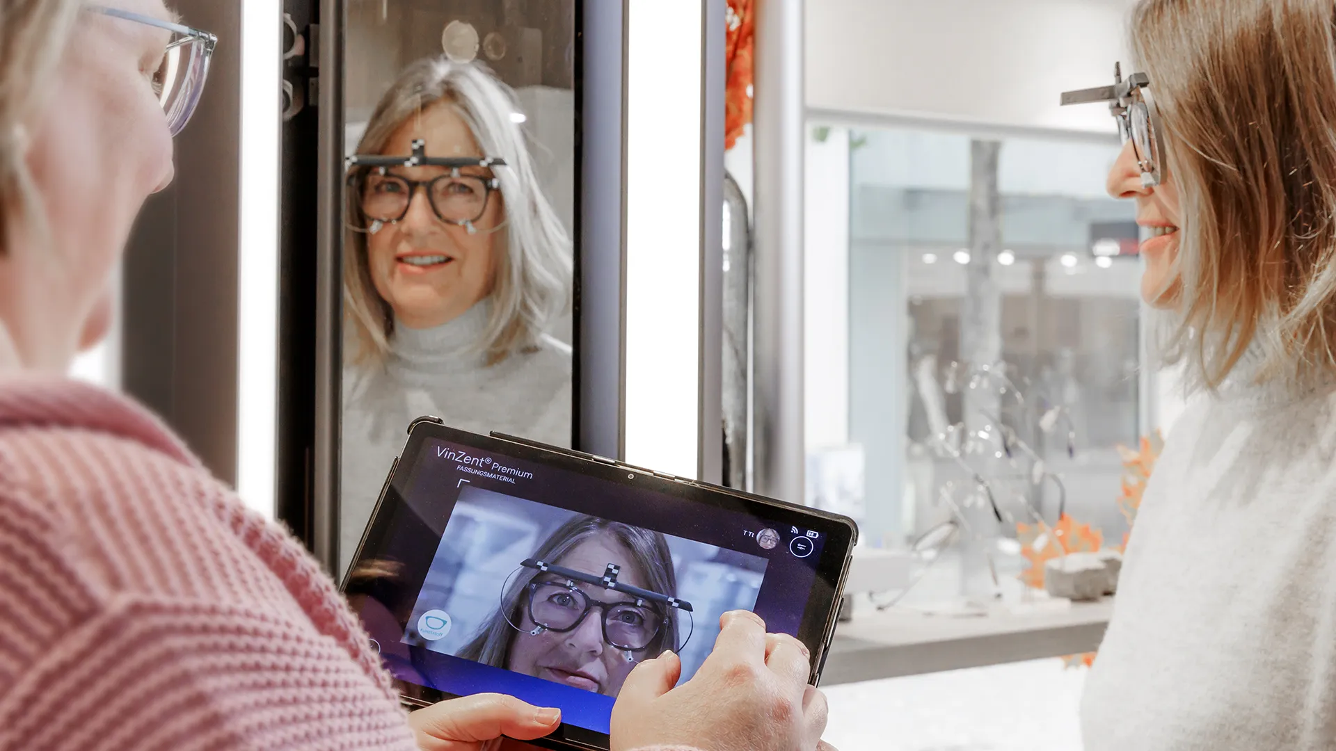 Kerstin Pürschel misst mit VinZent Premium die Brillenglas-Zentrierung einer Kundin – Messbrille, Tablet und Spiegel im Einsatz